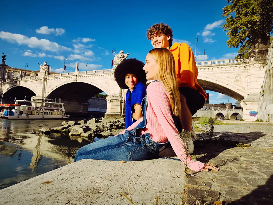 Fiatalok a folyóparton ülnek, színes kép